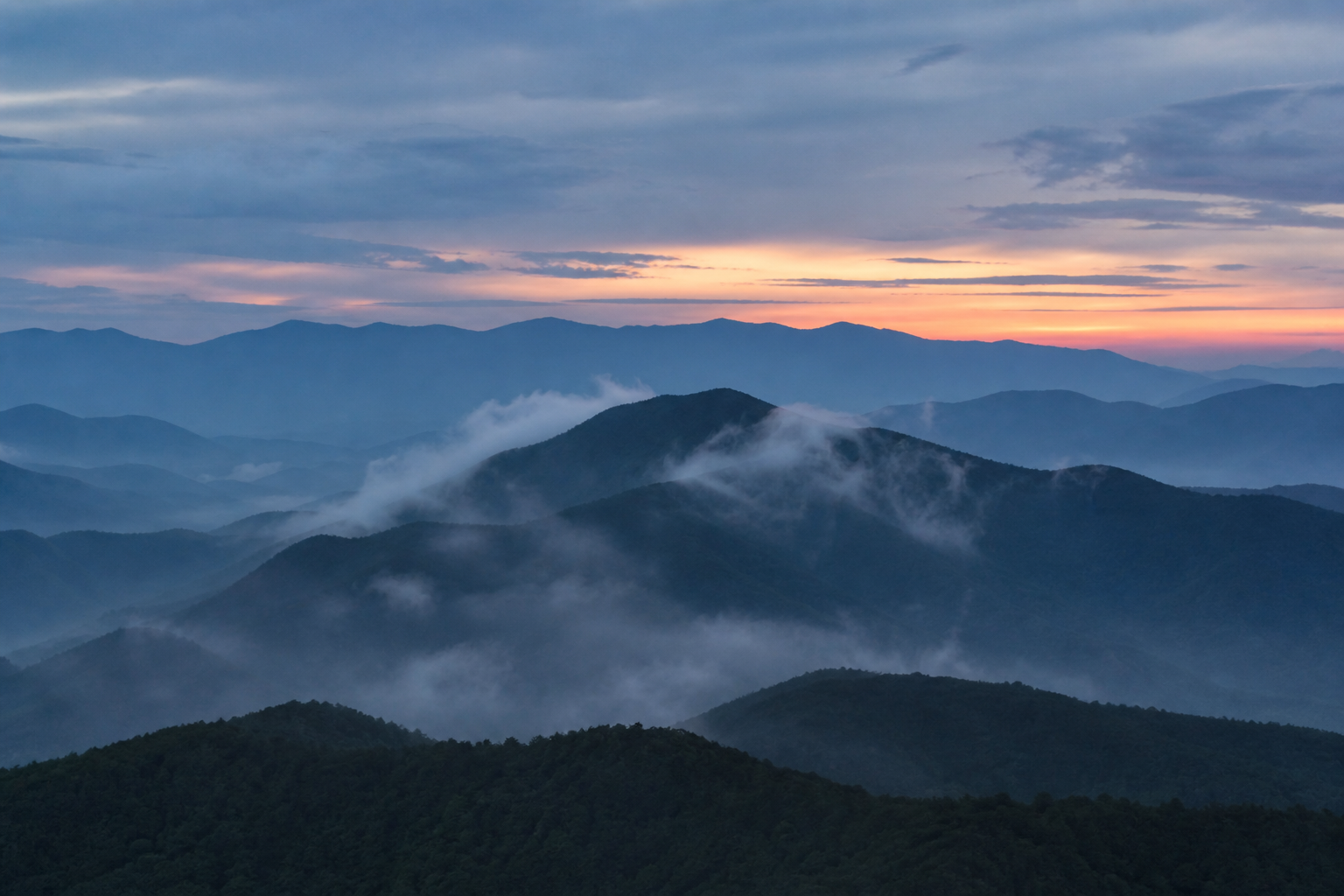 Generated demonstration image of misty mountain ridges at dawn.