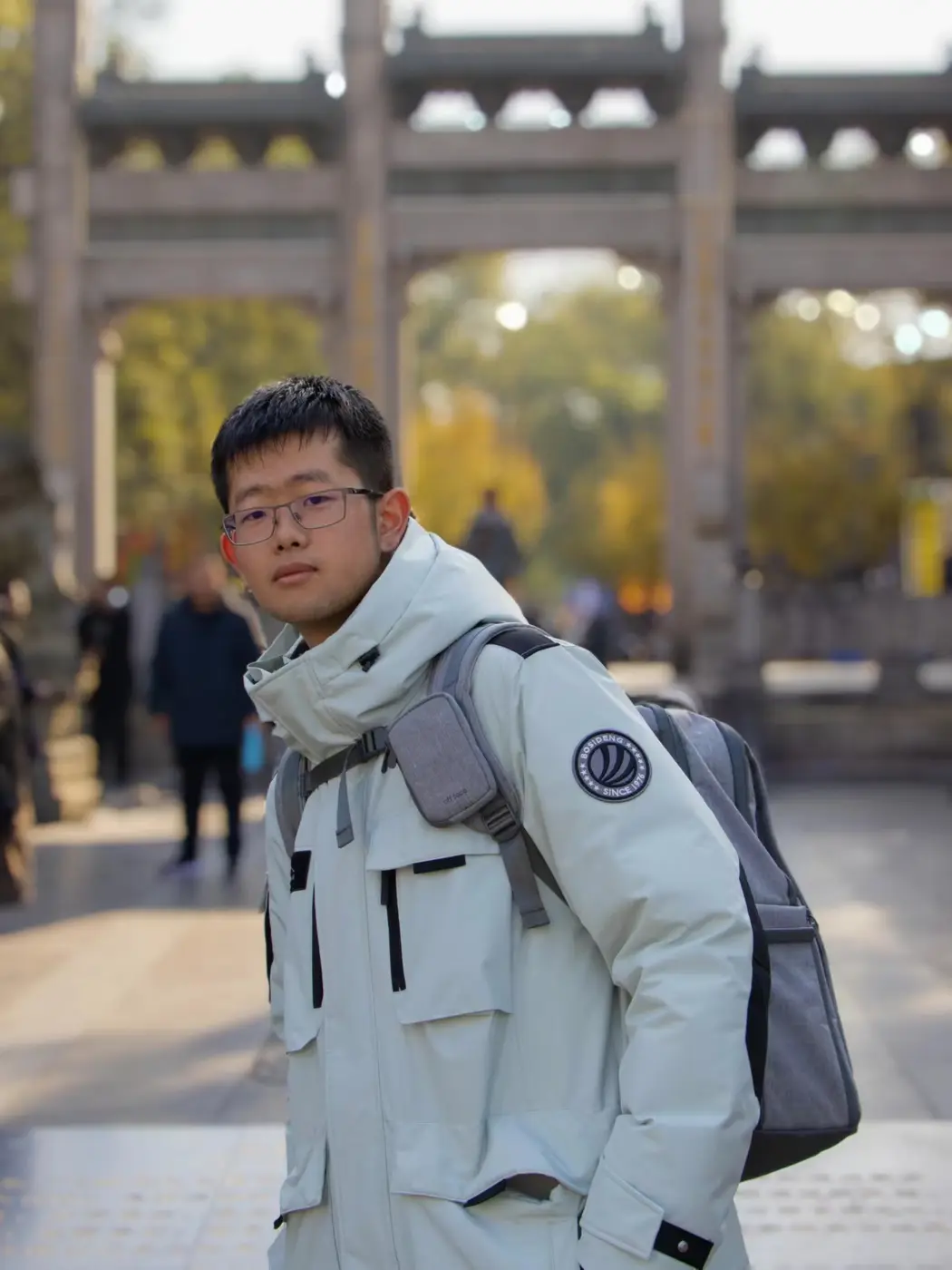 Portrait of Xiaoxi Zeng outdoors, wearing glasses and a light jacket